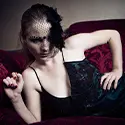 Gothic Boudoir with a woman wearing black outfit with a serious look on her face.