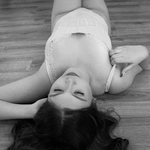 Shaylee laying on the wood floor in black and white.